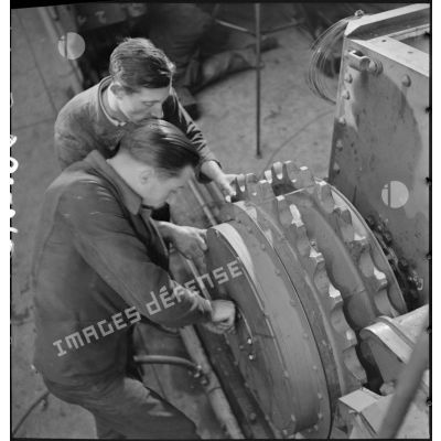 A l'atelier d'Issy-les-Moulineaux deux ouvriers travaillent sur le barbotin d'un char B 1 bis.
