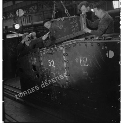 A l'atelier d'Issy-les-Moulineaux des ouvriers placent des plaques de blindage sur une caisse de char B1 bis.