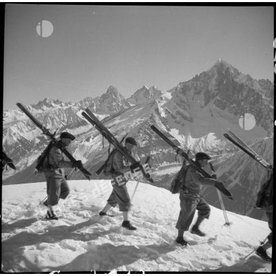 Skis sur l'épaule, des éclaireurs-skieurs du 199e BCHM gravissent en colonne une pente enneigée du Brévent.