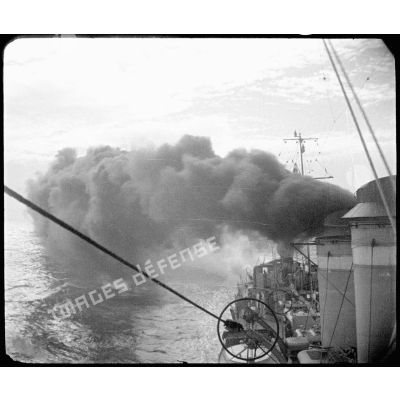 Une des cheminées d'un torpilleur émet une fumée épaisse.