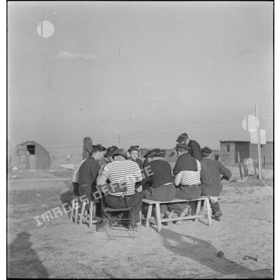 Des marins prennent un repas à proximité de leurs baraquements.