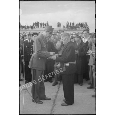 Au cours d'une cérémonie, le général de Gaulle remet la Croix de la Libération à Jean-Noël Marzin, maire de l'Ile de Sein. L'île a été nommée compagnon de l'ordre par décret du 1er janvier 1946.