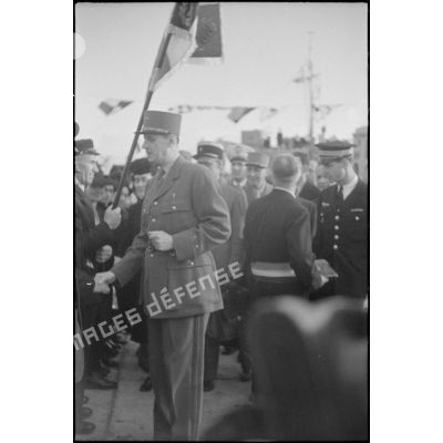 Le général de Gaulle salue des anciens combattants lors de la cérémonie de remise de la Croix de la Libération aux Sénans.