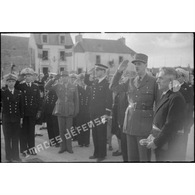Les autorités militaires saluent pendant l'exécution de la Marseillaise, à l'issue de la cérémonie de remise de la Croix de la Libération au maire de l'Ile de Sein par le général de Gaulle.