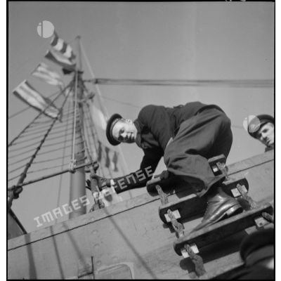 Marin de la Marine nationale montant à bord d'un navire marchand pour une fouille dans le cadre du blocus contre l'Allemagne.