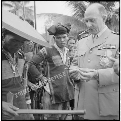 Lors d'une visite à Ban Me Thuot, le général de Lattre de Tassigny rencontre un groupe de la garde montagnarde qui lui présente son armement.