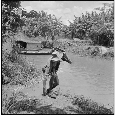 Un sergent du 43e régiment d’infanterie colonial (43e RIC) rapporte des grenades Viêt-minh récupérées lors de la fouille du rach.