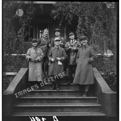 Photographie de groupe d'officiers français de la 1re armée sur le perron d'une maison.