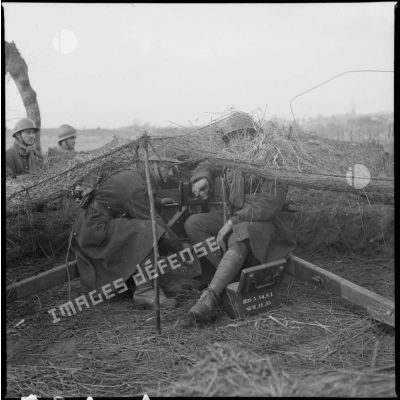 Des servants d'un canon antichars de 25 mm sont photographiés près de la culasse de l'arme.