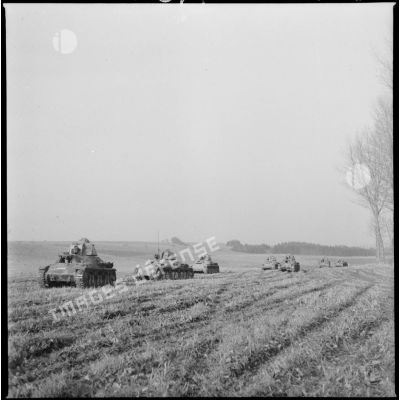Une colonne de chars légers Hotchkiss M35 H du 4e Cuirassiers ou 18e RD est photographiée en plan général de trois quarts avant alors que les chars progressent sur un terrain plat.