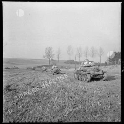 Une colonne de chars légers Hotchkiss M35 H du 4e Cuirassiers ou 18e RD est photographiée en plan général de trois quarts arrière alors que les chars progressent sur un terrain plat.