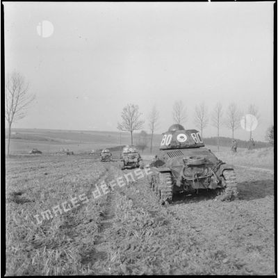 Une colonne de chars légers Hotchkiss M35 H du 4e Cuirassiers ou 18e RD est photographiée en plan général de trois quarts arrière alors que les chars progressent sur un terrain plat.