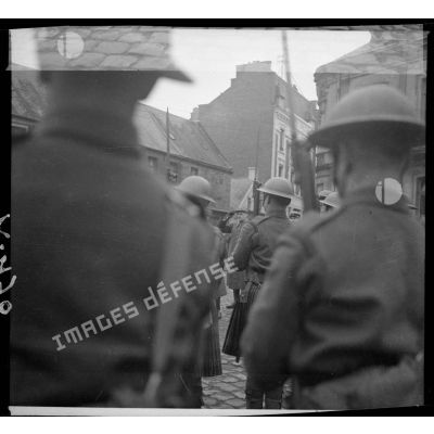 Des troupes écossaises de la BEF sont photographiées de dos en plan moyen lors d'une cérémonie militaire.