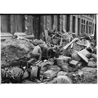 Plan général d'ouvriers qui travaillent dans une rue de Valenciennes transformées en champ de ruines.