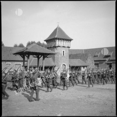 Plan général de soldats de la BEF (British expeditionary force) qui font de l'ordre serré dans une cour de ferme.
