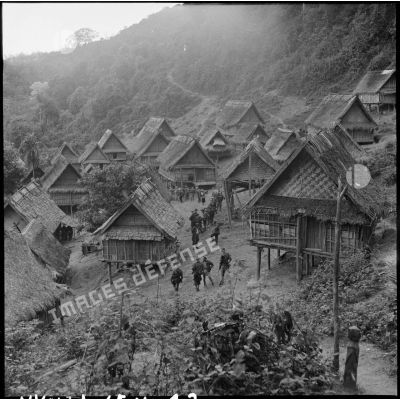 Des soldats de la colonne Godard traversent le village de Phu Teng lors de l'opération Condor.