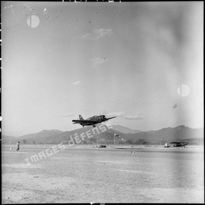 Un avion bombardier SB2C Helldiver de la 3e flottille d'assaut de l'aéronavale survole le terrain d'aviation du camp de Diên Biên Phu.
