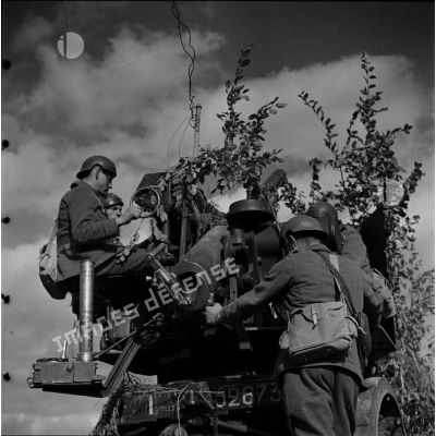 [Les servants d'un canon camouflé de 75 mm CA autocanon M1913/1934 du 402e RADCA (régiment d'artillerie de défense contre avions) le dirigent vers l'objectif, Moselle, 18-22 octobre 1939.]