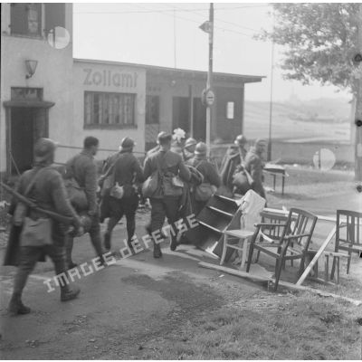 [Des soldats du 11e GRCA (groupe de reconnaissance de corps d'armée) passent un poste frontière à Lauterbach (Sarre) Septembre-octobre 1939.]