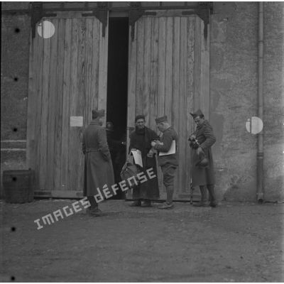[Abbé vendant des journaux à des soldats, ferme Moncillon, Moselle. 26 octobre 1939.]