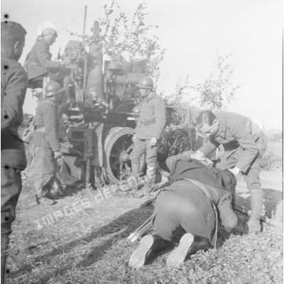 [Une équipe de tournage filme les servants d'un canon camouflé de 75 mm CA autocanon M1913/1934 du 402e RADCA (régiment d'artillerie de défense contre avions). Gavisse (Moselle), 18-22 octobre 1940.]