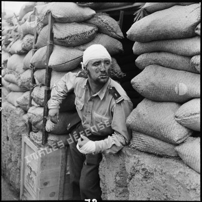 Un lieutenant de la Légion étrangère blessé pendant la bataille observe l'entrée d'un point d'appui (PA) les effets des tirs dirigés contre le Viêt-minh.