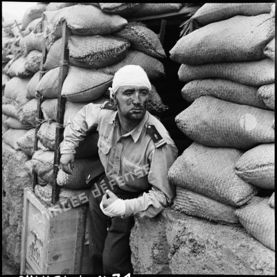 Un lieutenant de la Légion étrangère blessé pendant la bataille observe de l'entrée d'un point d'appui (PA) les effets des tirs dirigés contre le Viêt-minh.