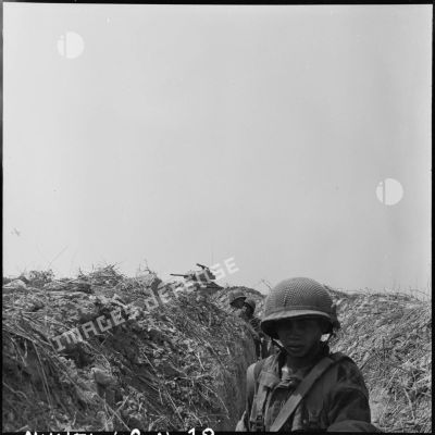 Des soldats dans une tranchée lors d'une contre-attaque appuyée par des blindés et l'aviation, au sud de Diên Biên Phu.