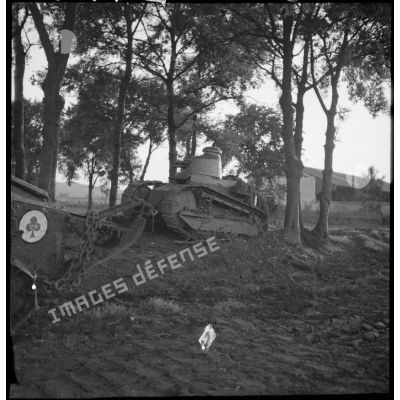 Des chars légers Renault FT 17 sont photographiés en plan général dans un bois bordant un champ.