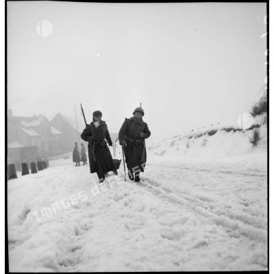 Deux soldats de la 2e armée tirent un traîneau sur la neige.