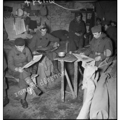 Des soldats de la 2e armée lisent dans leur baraquement.