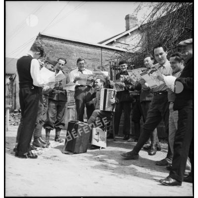 Photographie de groupe de soldats de la 2e armée qui chantent et jouent de l'accordéon.