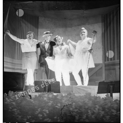 Sur une scène, photographie de groupe de comédiens lors d'une représentation du théâtre aux armées.