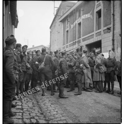 Dans une rue de Stenay des soldats de la 2e armée attendent une séance de cinéma aux armées.
