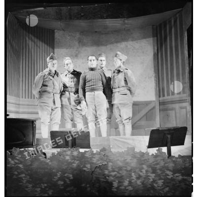 Sur une scène, photographie de groupe de comédiens d'un théâtre aux armées.