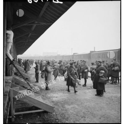 Plan général de permissionnaires de la 2e armée qui attendent près d'une gare ferroviaire.