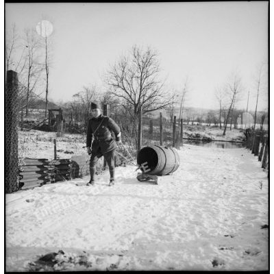 Dans la neige plan général d'un soldat qui tire un tonneau d'eau posé sur un traîneau.