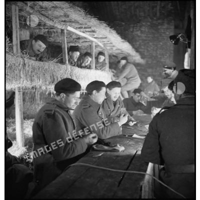 Photographie de groupe de soldats de la 2e armée qui se détendent à l'intérieur d'un abri de campagne.