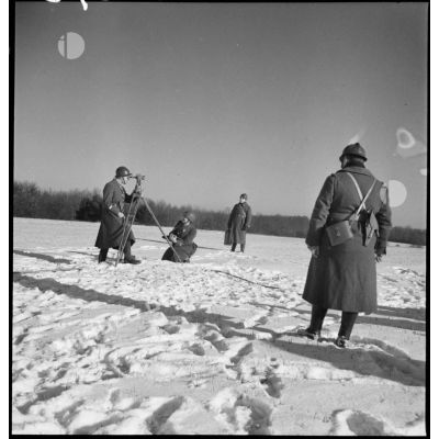 Dans un paysage enneigé, des lieutenants artilleurs de la 2e armée effectuent des relevés topographiques.