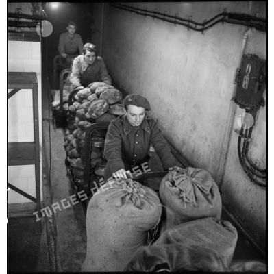 Des soldats du 155e RIF et peut-être du 17e RA poussent des chariots de pains dans un couloir de l'ouvrage de Velosnes.
