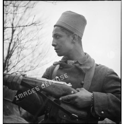Portrait d'un tirailleur du 15e RTA posté fusil en main.