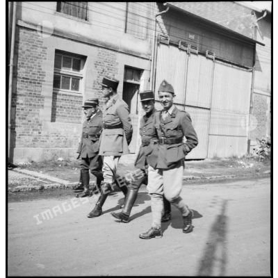 Photographie de groupe d'officiers de la 2e armée qui marchent dans une rue.