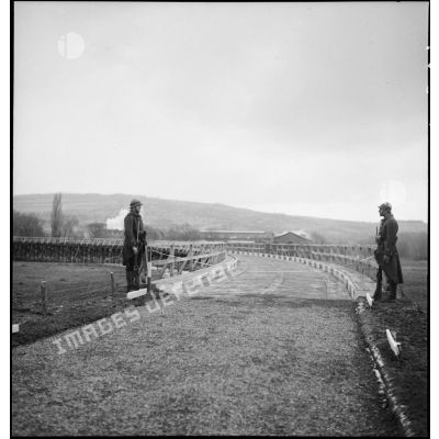 Deux sentinelles de la 2e armée montent la garde sur un pont de bois.