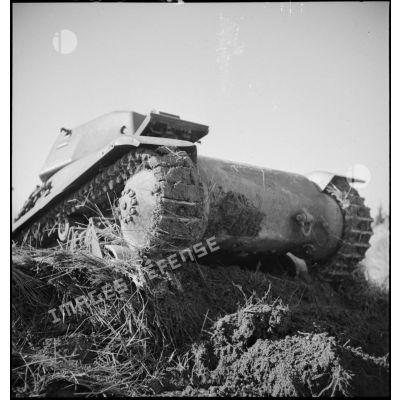 Un char léger Hotchkiss M35/39H de la 2e armée est photographié de trois quarts avant en contre-plongée alors qu'il franchit un fossé.
