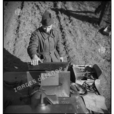 Un mécanicien est photographié en plongée alors qu'il se tient debout devant un Hotchkiss M35/39 H.