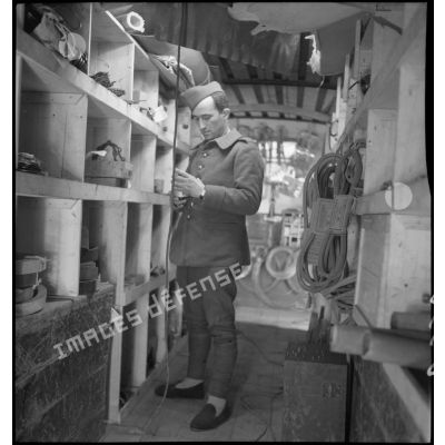 Un mécanicien cherche une pièce mécanique dans le magasin de l'atelier de réparation de campagne.