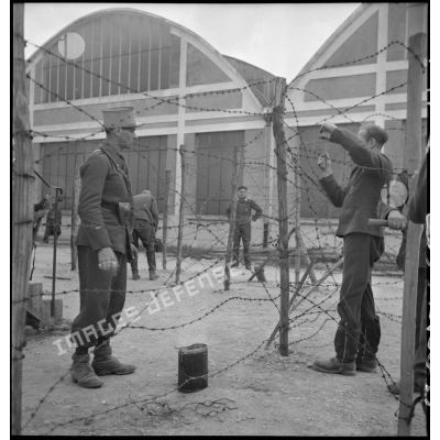 Des soldats français mettent en place des barbelés dans un camp de prisonniers du secteur de la 2e armée.