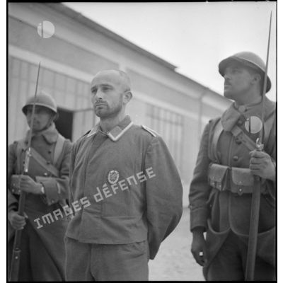 Portrait d'un sergent radio de la Luftwaffe encadré par deux tirailleurs de la 3e DINA dans un camp de prisonniers du secteur de la 2e armée.