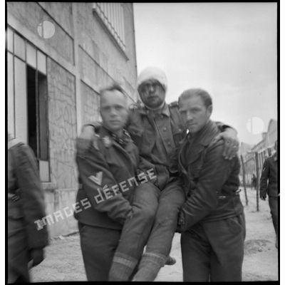 Deux prisonniers allemands portent un blessé à la tête dans un camp de prisonniers du secteur de la 2e armée.