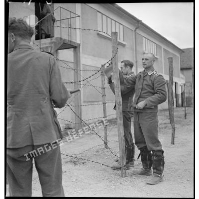 Photographie de groupe d'aviateurs allemands qui mettent en place des barbelés dans un camp de prisonniers du secteur de la 2e armée.